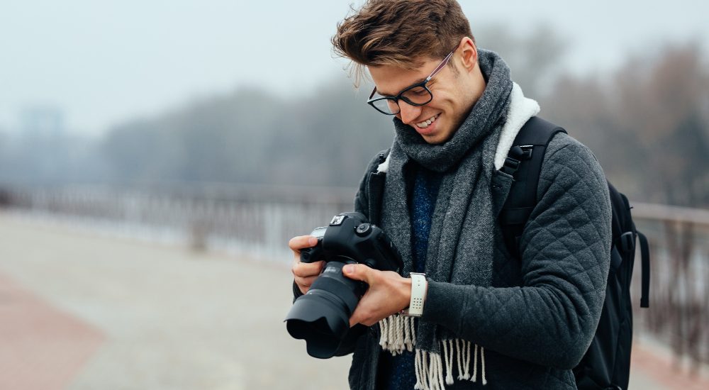 Cheerful handsome man eyeglasses looks photos camera