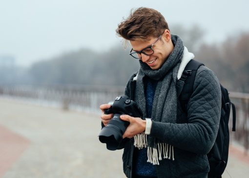 Cheerful handsome man eyeglasses looks photos camera